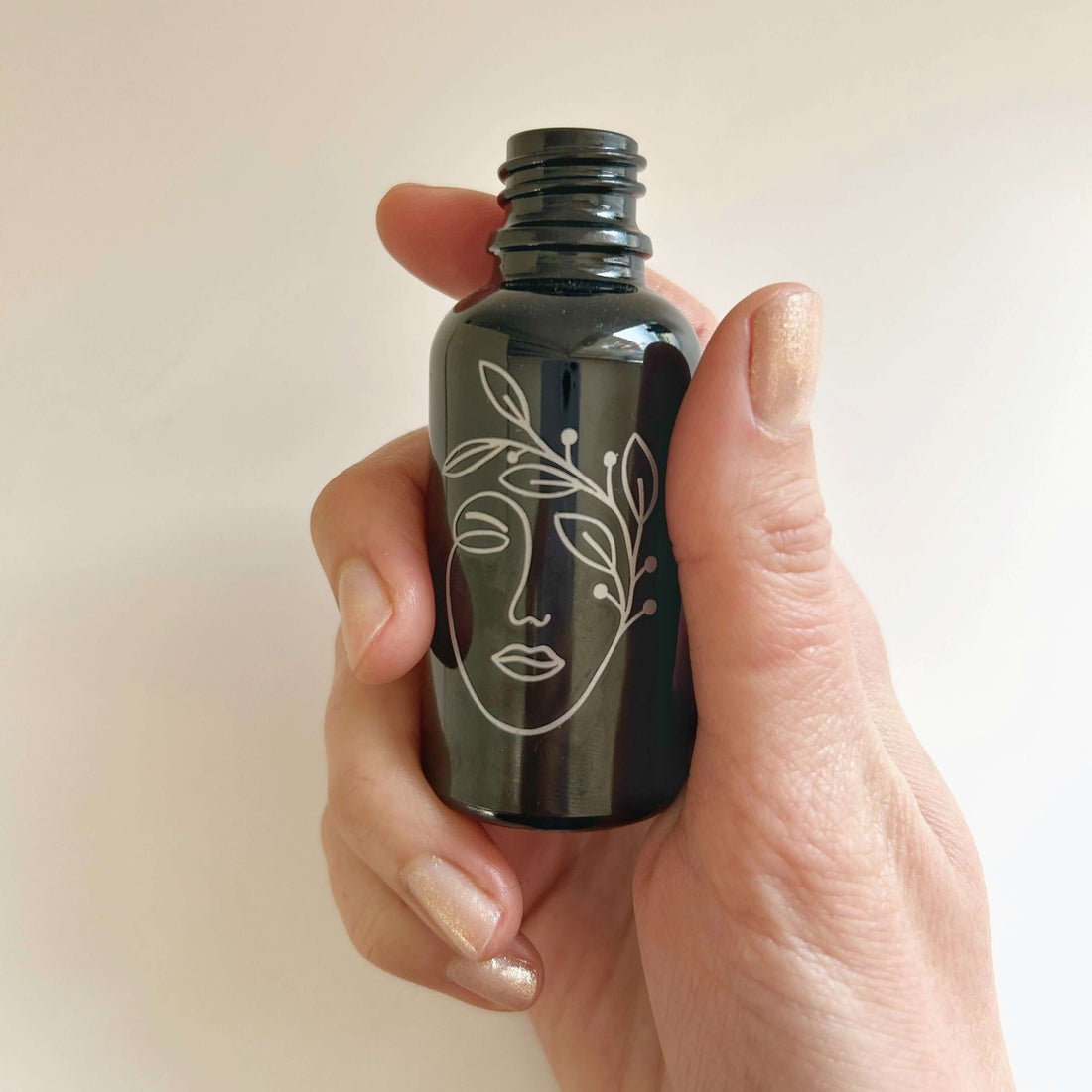 flacon vide d'huile essentielle motif visage de femme